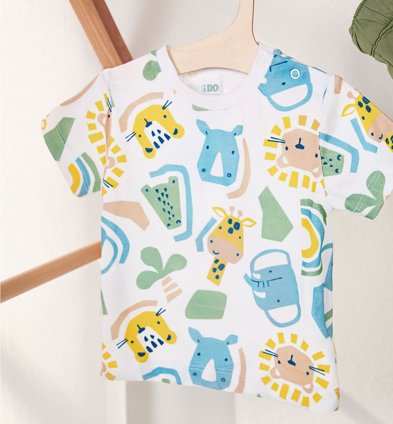 T-shirt bimbo con stampa colorata di animali della savana su fondo bianco.

