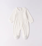 Tutina neonata in ciniglia bianco latte con ricamo nido d’ape piegata.