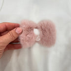 Dettaglio fiocco in pelliccia rosa sulla tutina panna in ciniglia