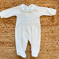 Tutina neonato in ciniglia color cielo con colletto bianco ricamato e fiocchetti.