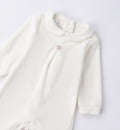 Dettaglio tutina unisex in ciniglia panna con stellina beige ricamata.