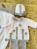 Cappellino neonata in lana rosa con bordo beige e lavorazione a maglia