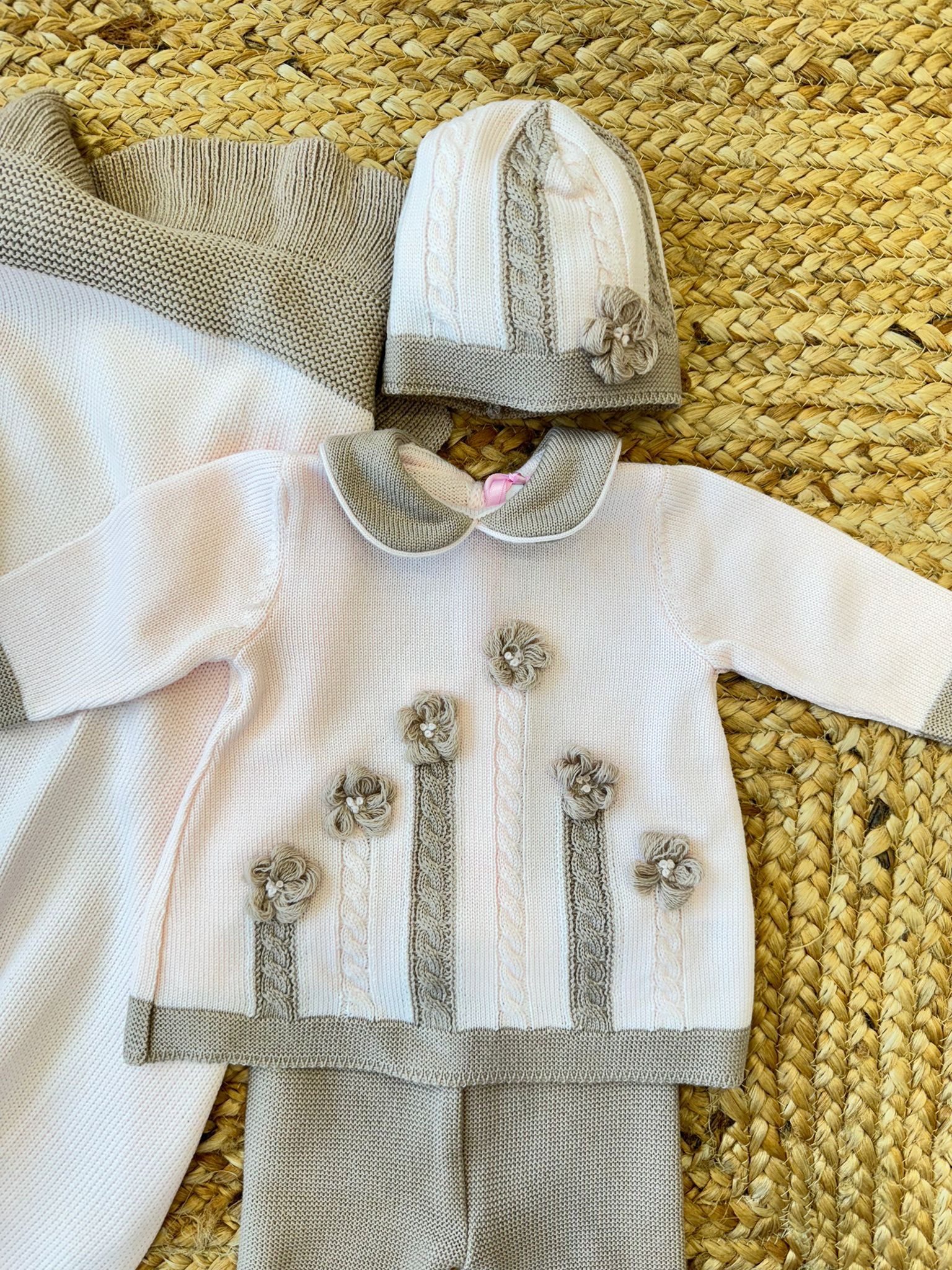 Cappellino neonata in lana rosa con bordo beige e lavorazione a maglia