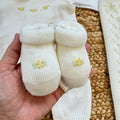Uscita clinica neonata in pura lana bianco latte con tutina, copertina, cappellino e scarpette con fiorellini gialli.