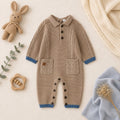 Dettaglio tutina neonato in maglia con orsetto beige, colletto azzurro e finiture a contrasto
