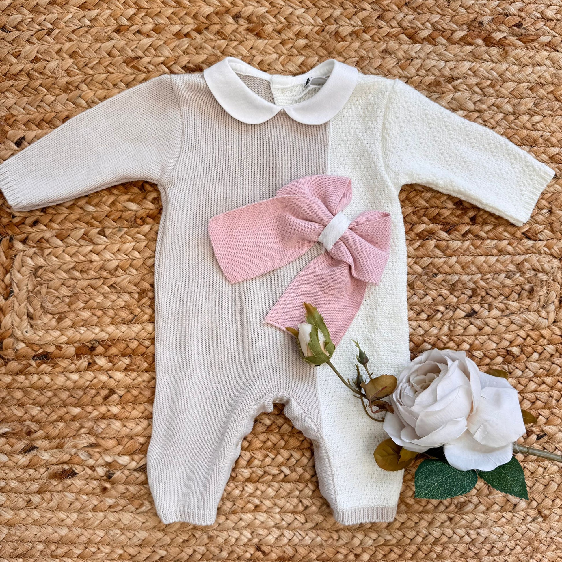 Tutina neonata in maglia bicolore panna e beige con maxi fiocco rosa, ideale per l’autunno inverno