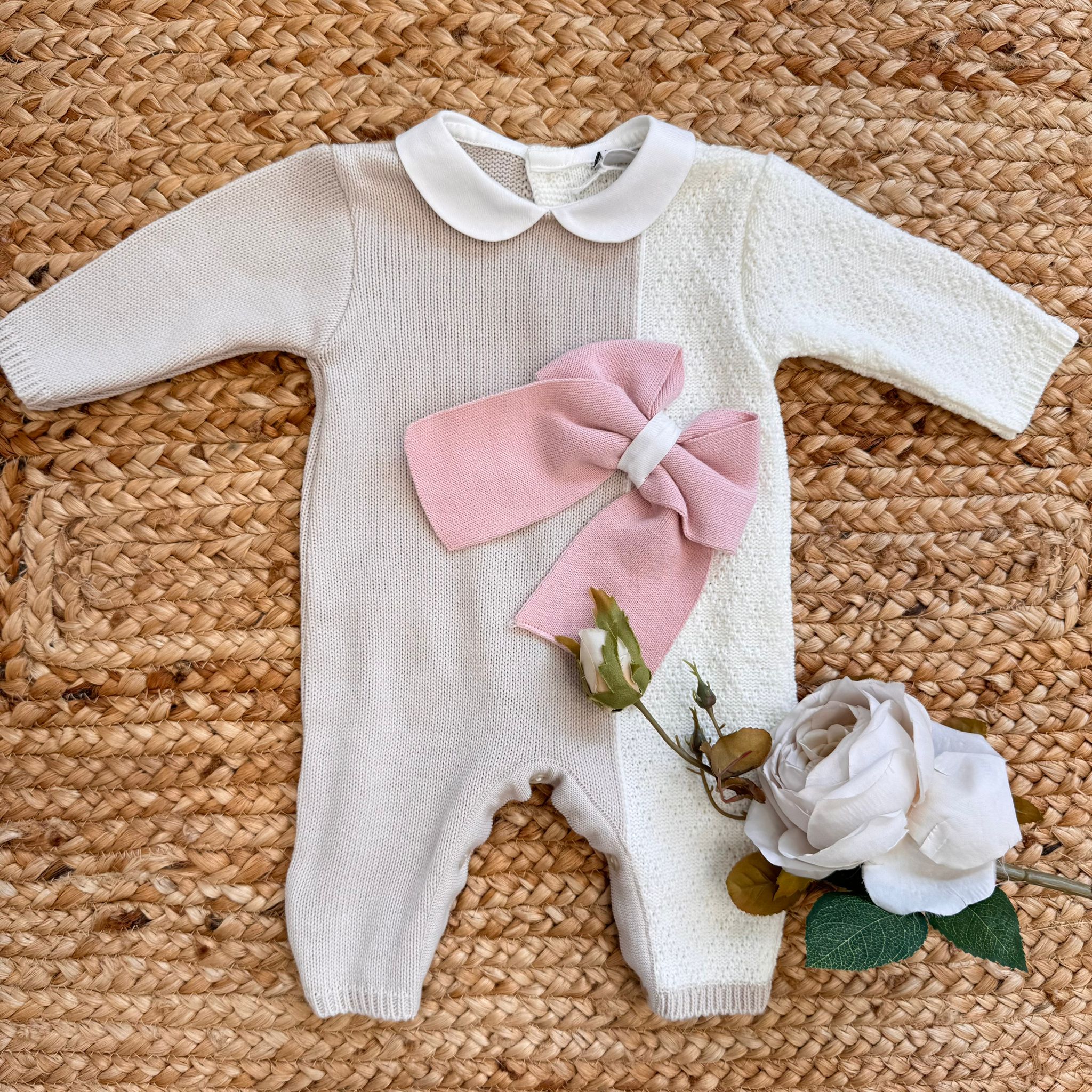 Tutina neonata in maglia bicolore panna e beige con maxi fiocco rosa, ideale per l’autunno inverno