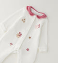 Tutina nascita neonata in ciniglia bianca con colletto rosa, ricami floreali e piedini integrati