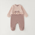 Tutina neonata in ciniglia rosa con fiocco, volant e piedini, ideale per corredino nascita bambina.
