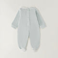 Dettaglio tutina neonata verde menta in ciniglia con colletto bianco e lavorazione smock geometrica