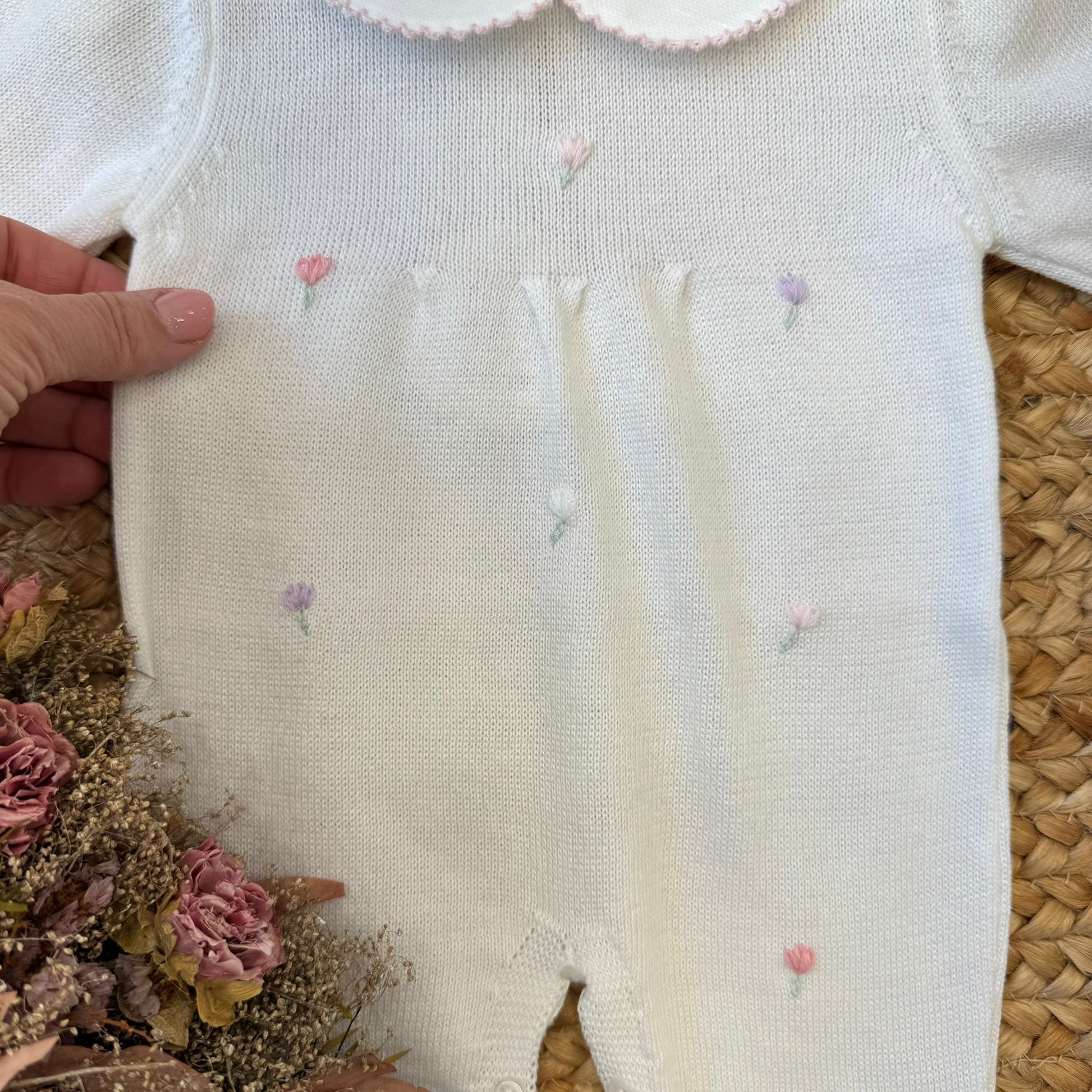 Ricami floreali su tutina neonata in cotone