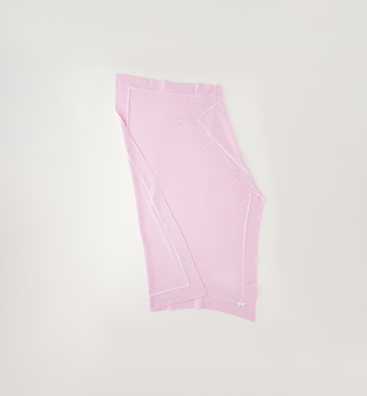 Dettaglio lavorazione traforata e fiocco bianco