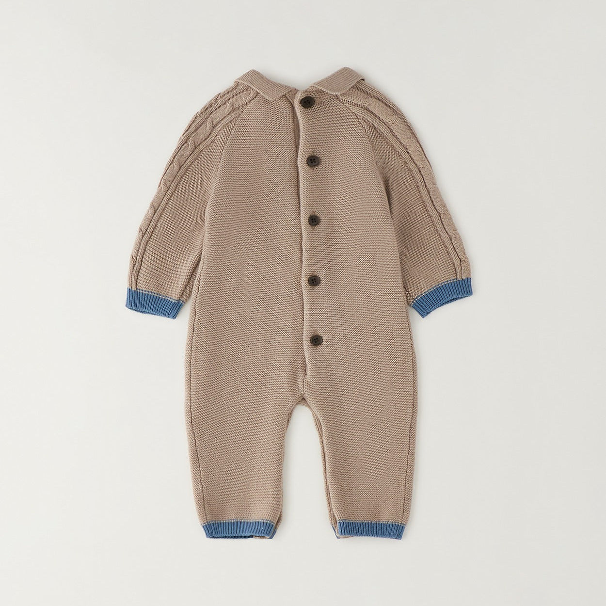 Tutina neonato tricot beige in 80% cotone e 20% lana con trecce, taschine e dettagli petrolio