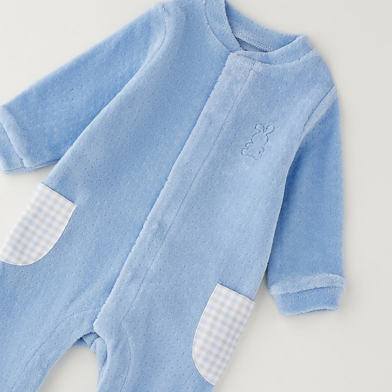 Tutina neonato in ciniglia azzurra con coniglietto ricamato e taschine a quadretti