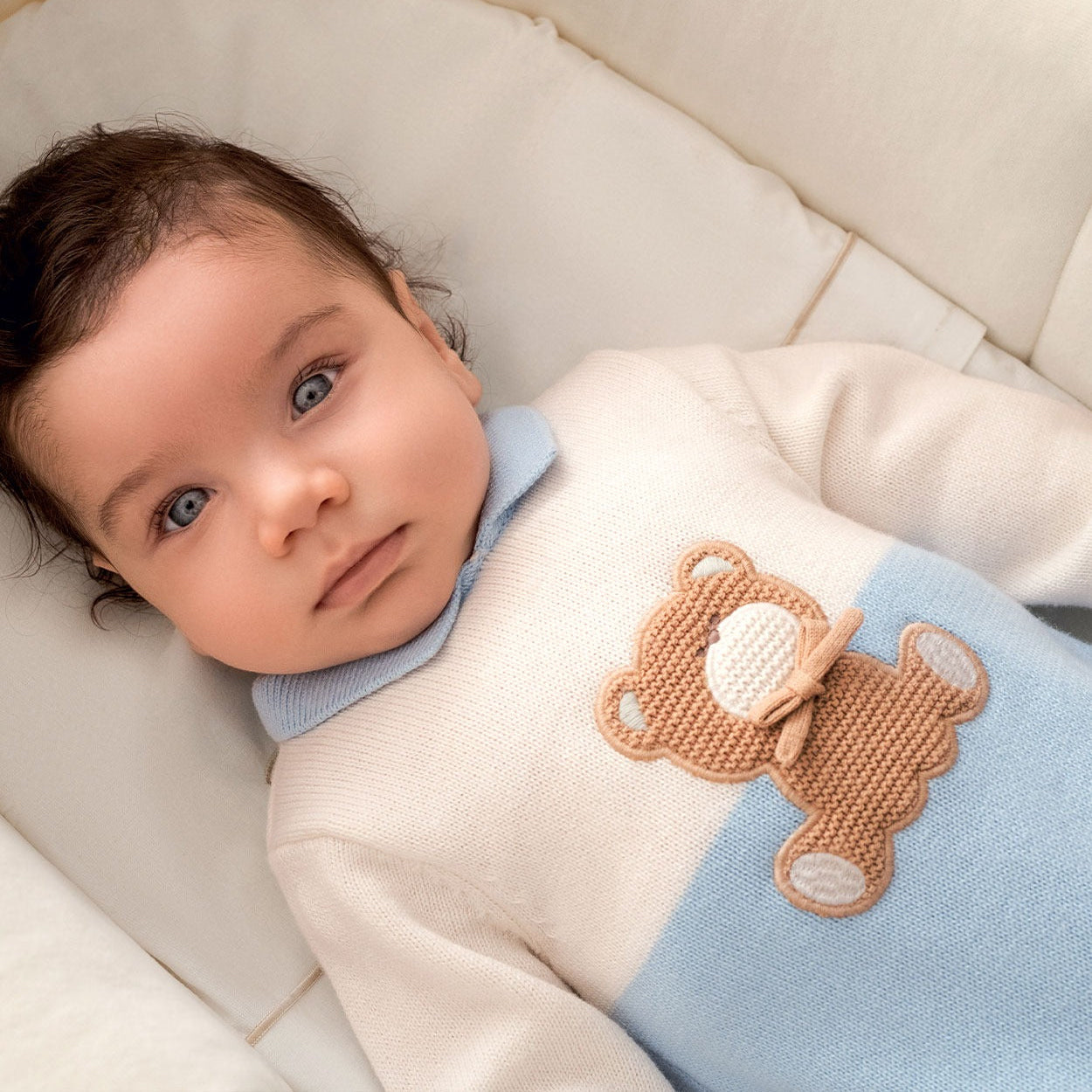 Tutina neonato in cotone e lana bianca e azzurra con orsetto beige indossata