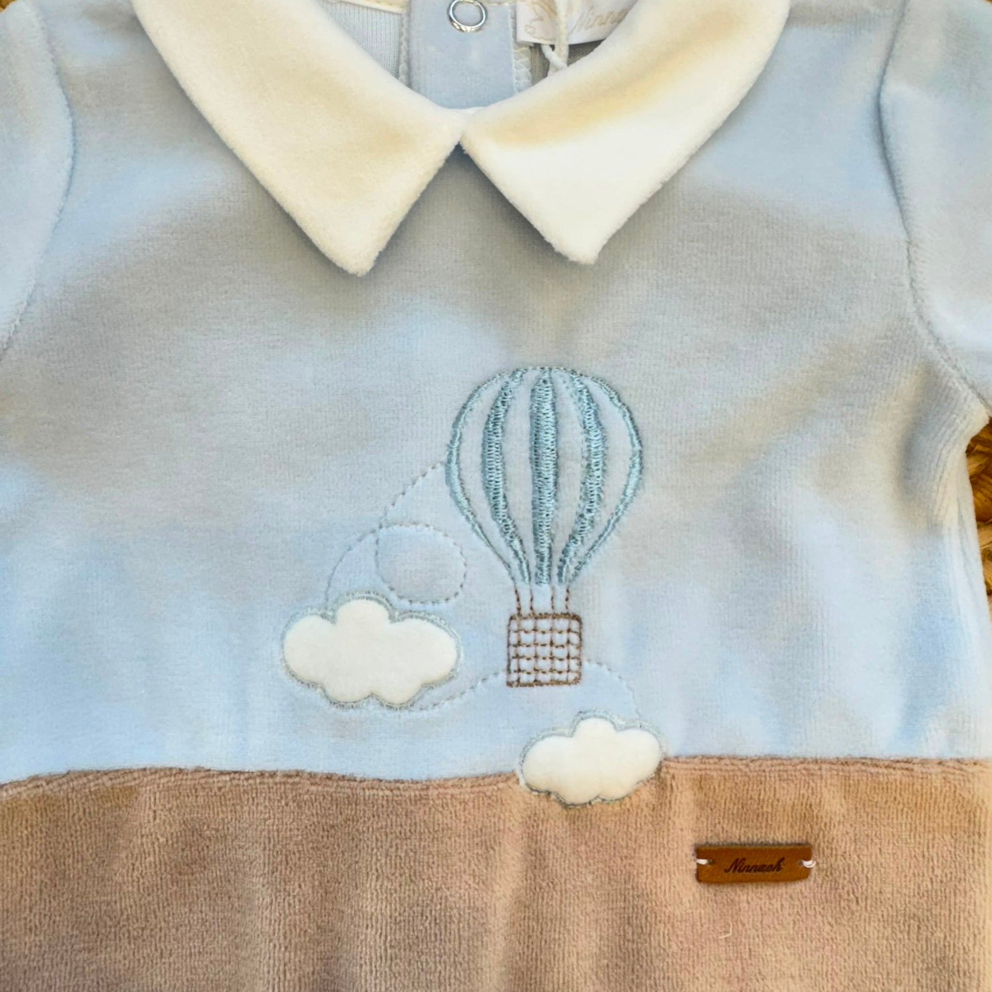 Tutina neonato in ciniglia azzurro cielo e beige con ricamo mongolfiera Made in Italy.