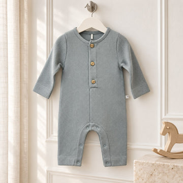 Tutina neonato in cotone 100% azzurro polvere a costine, con maniche lunghe, bottoncini frontali e apertura con automatici nell'interno gamba.