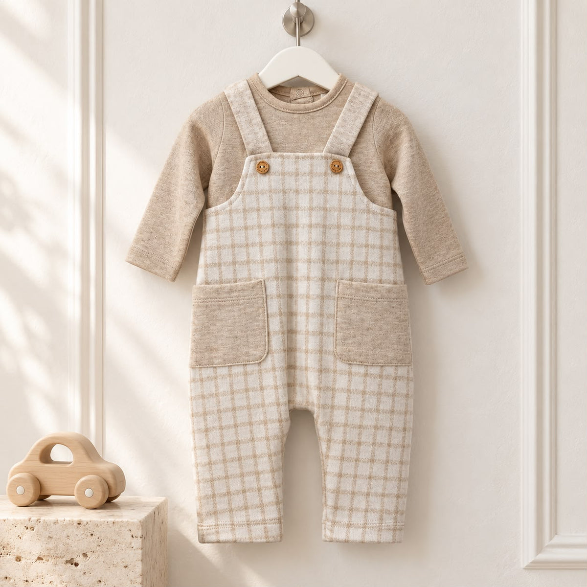 Tutina neonato in cotone beige e panna con salopette a quadretti, bretelle e taschine. Un completo raffinato per vestire il tuo bambino.