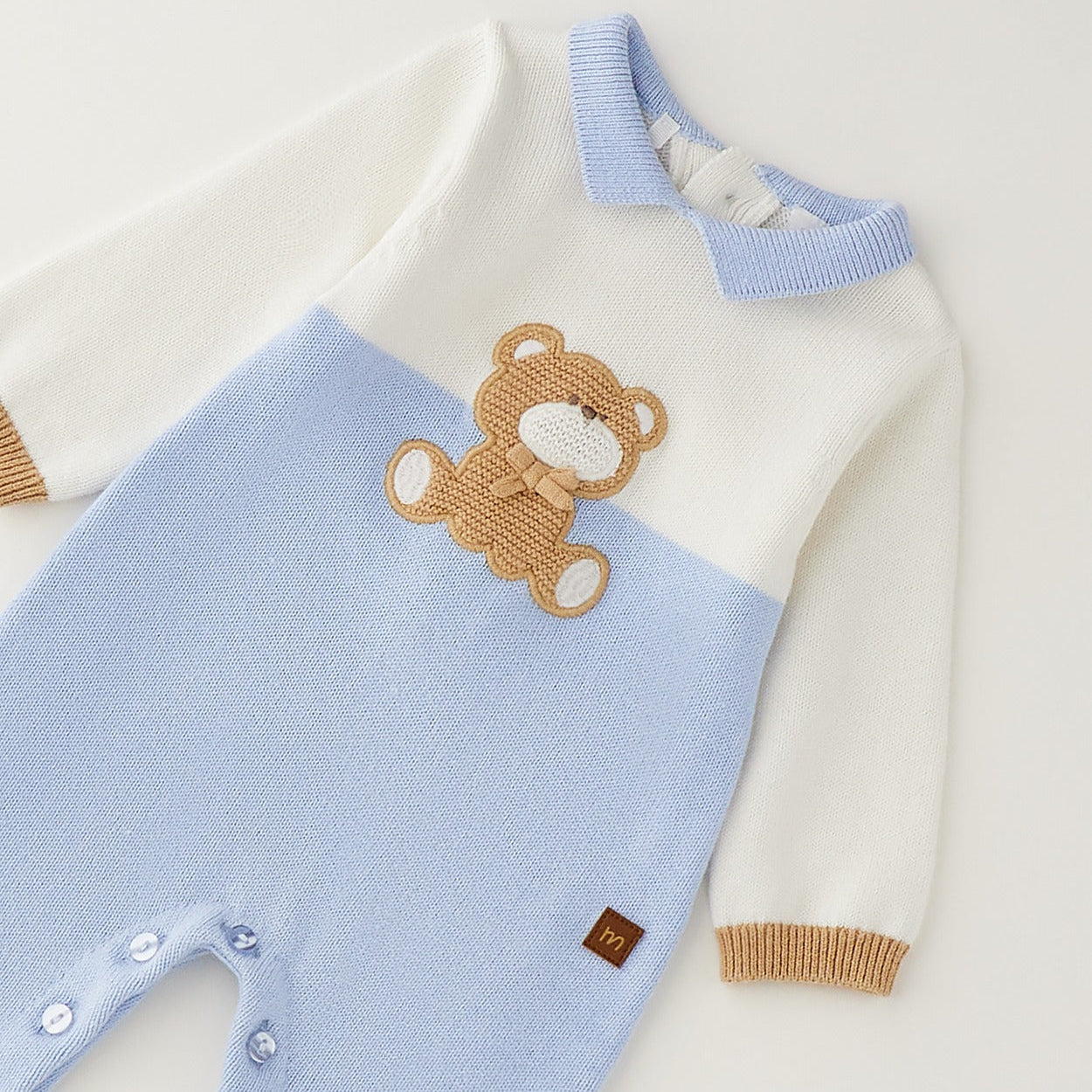 Tutina neonato in cotone e lana bianca e azzurra con orsetto beige indossata