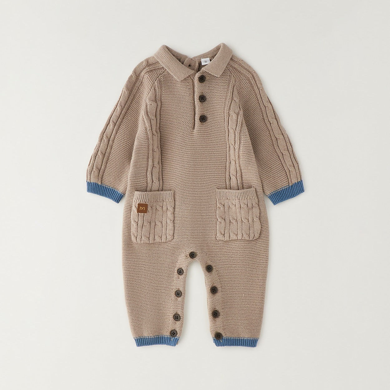 Tutina neonato tricot beige in 80% cotone e 20% lana con trecce, taschine e dettagli petrolio