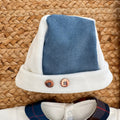 Dettaglio tutina neonato in ciniglia panna con inserto tartan e vellutino azzurro