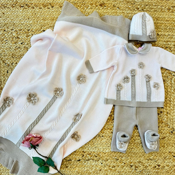 Cappellino neonata in lana rosa con bordo beige e lavorazione a maglia
