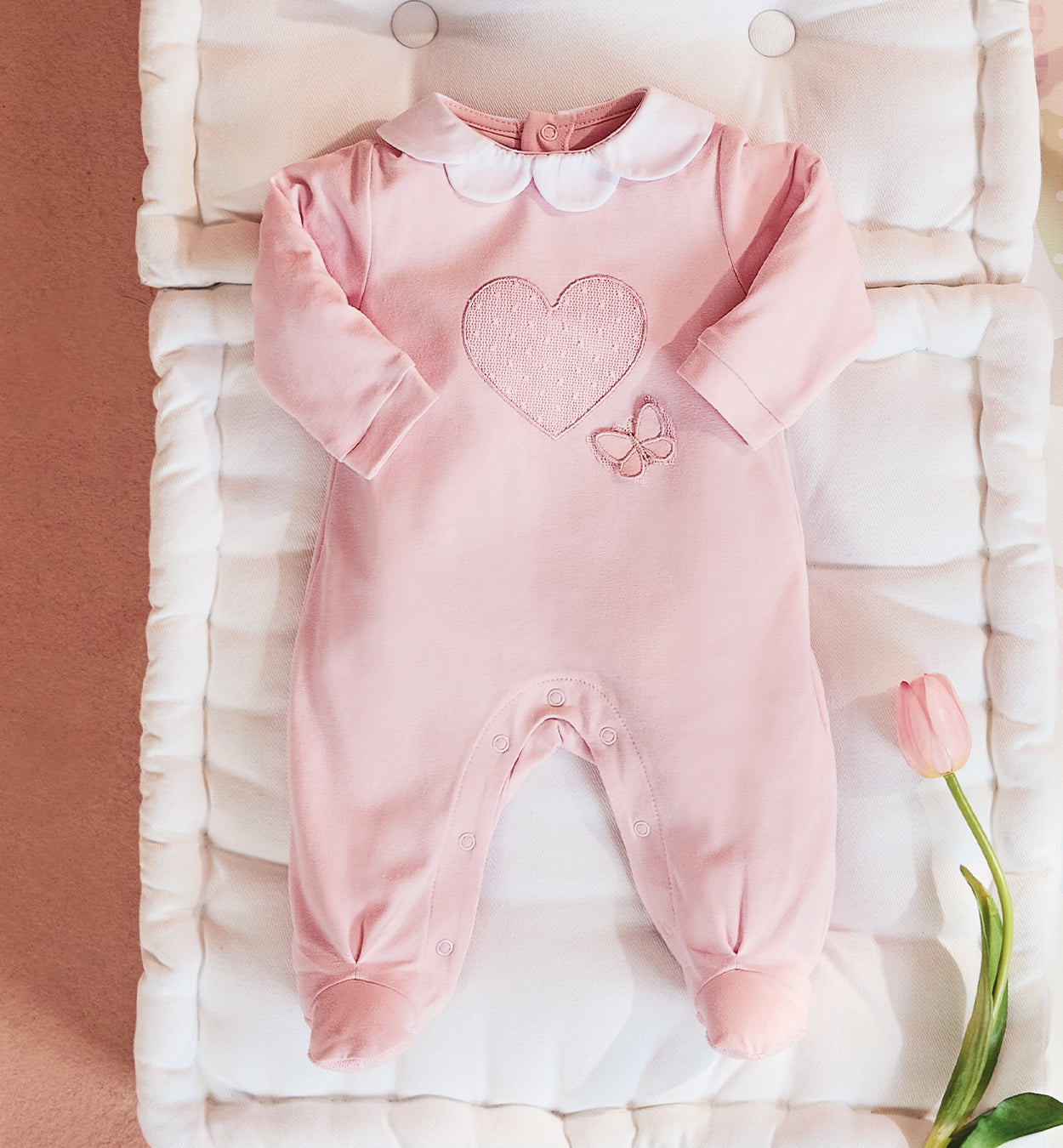 Delicata tutina in cotone rosa con ricamo cuore e farfalla, perfetta per i primi giorni della tua bambina. Realizzata in 100% cotone Made in Italy, garantisce morbidezza e comfort sulla pelle delicata del neonato. Il colletto in piqué bianco aggiunge un tocco di raffinatezza, mentre la chiusura con bottoncini a pressione sul retro e sul cavallo facilita il cambio.

Ideale per l’uscita clinica, le prime coccole a casa e le occasioni speciali. 