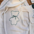 Dettaglio ricamo con nastro verde su maglia coordinata