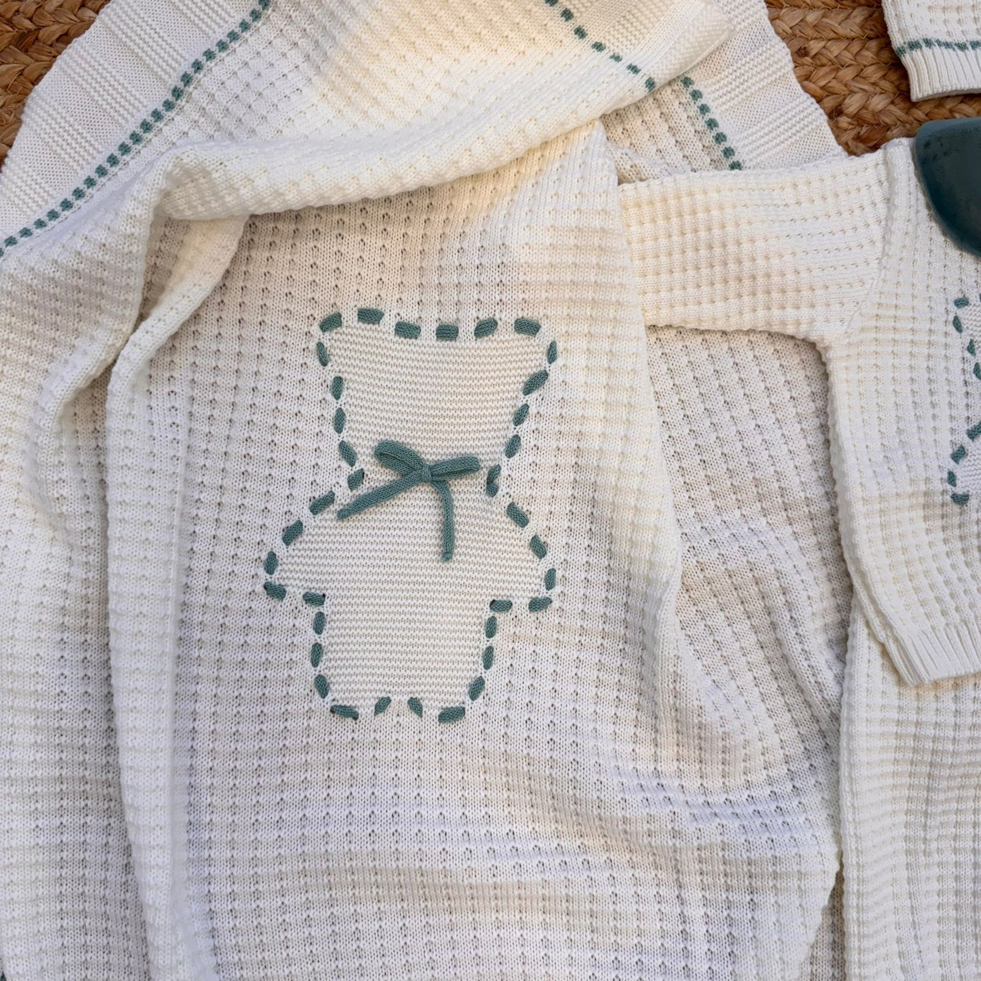 Dettaglio ricamo con nastro verde su maglia coordinata