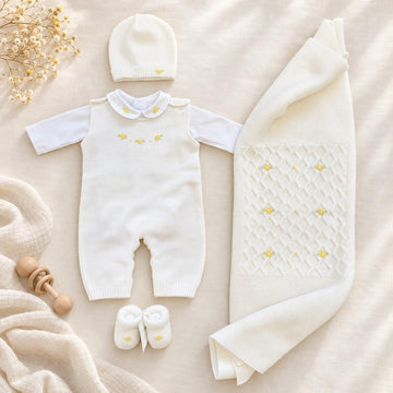 Uscita clinica neonata in pura lana bianco latte con tutina, copertina, cappellino e scarpette con fiorellini gialli.
