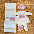 Uscita clinica neonata in pura lana bianca con fiocco rosa e copertina coordinata.