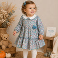 Abitino bimba floreale 100% cotone con colletto bianco e pon pon azzurri.
