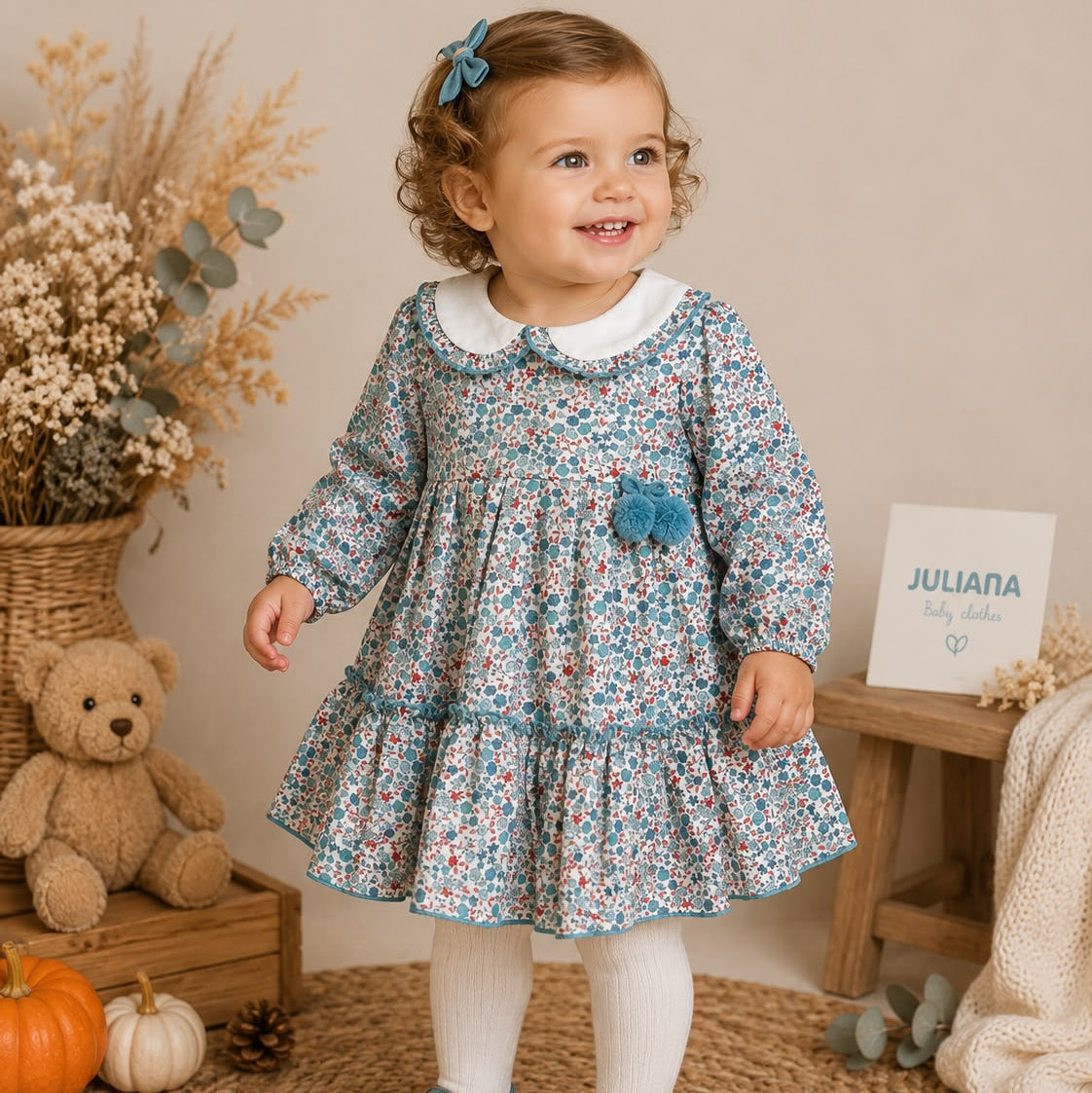 Abitino bimba floreale 100% cotone con colletto bianco e pon pon azzurri.