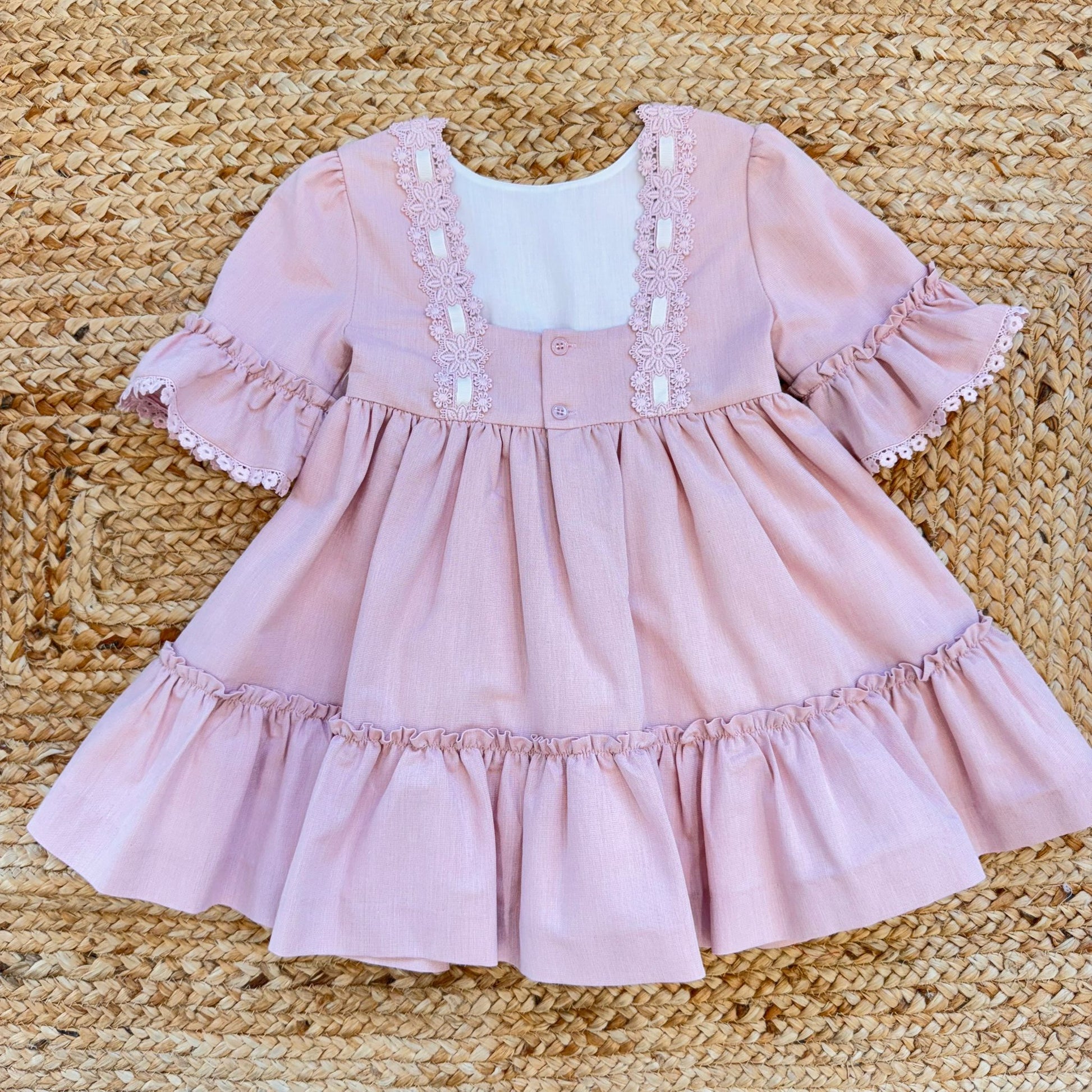 Vestito bambina elegante rosa cipria con pizzo in vita e balze morbide.