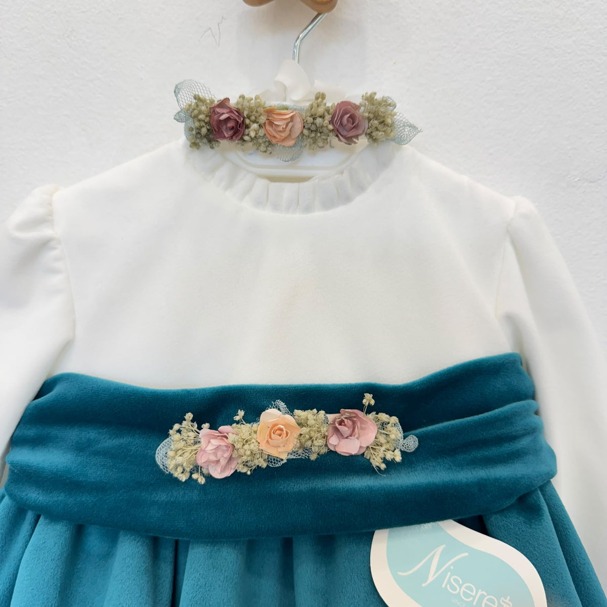 Dettaglio abito elegante bimba in velluto ottanio con corpetto panna e fiori rosa