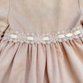 Vestito bambina elegante rosa cipria con pizzo in vita e balze morbide.