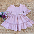 Vestito bambina elegante rosa cipria con pizzo in vita e balze morbide.