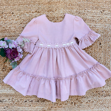 Vestito bambina elegante rosa cipria con pizzo in vita e balze morbide.