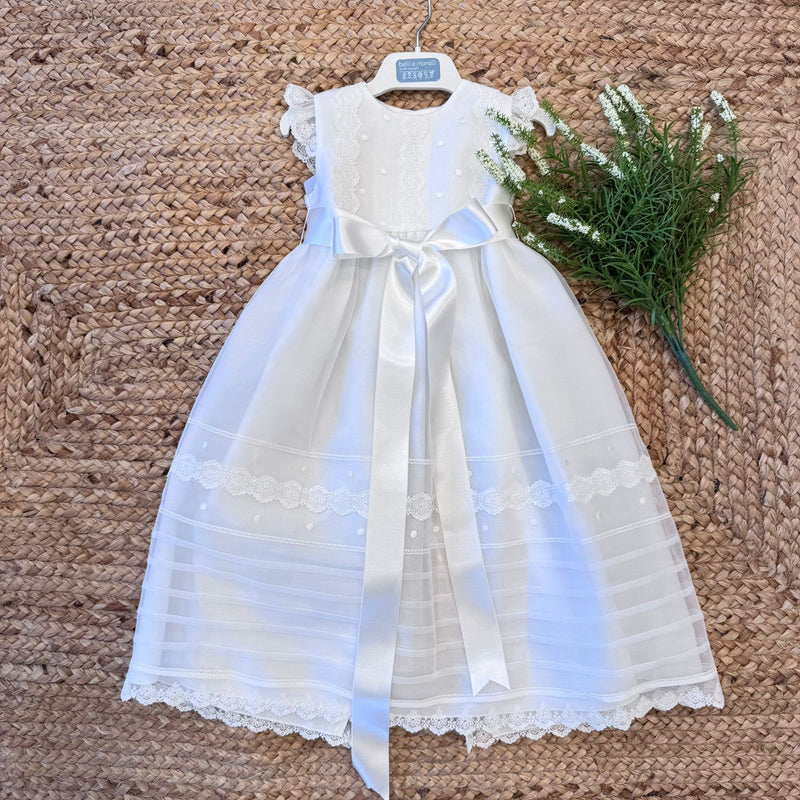 Abito da battesimo per neonata in tulle con fiocco in raso e pizzo floreale.