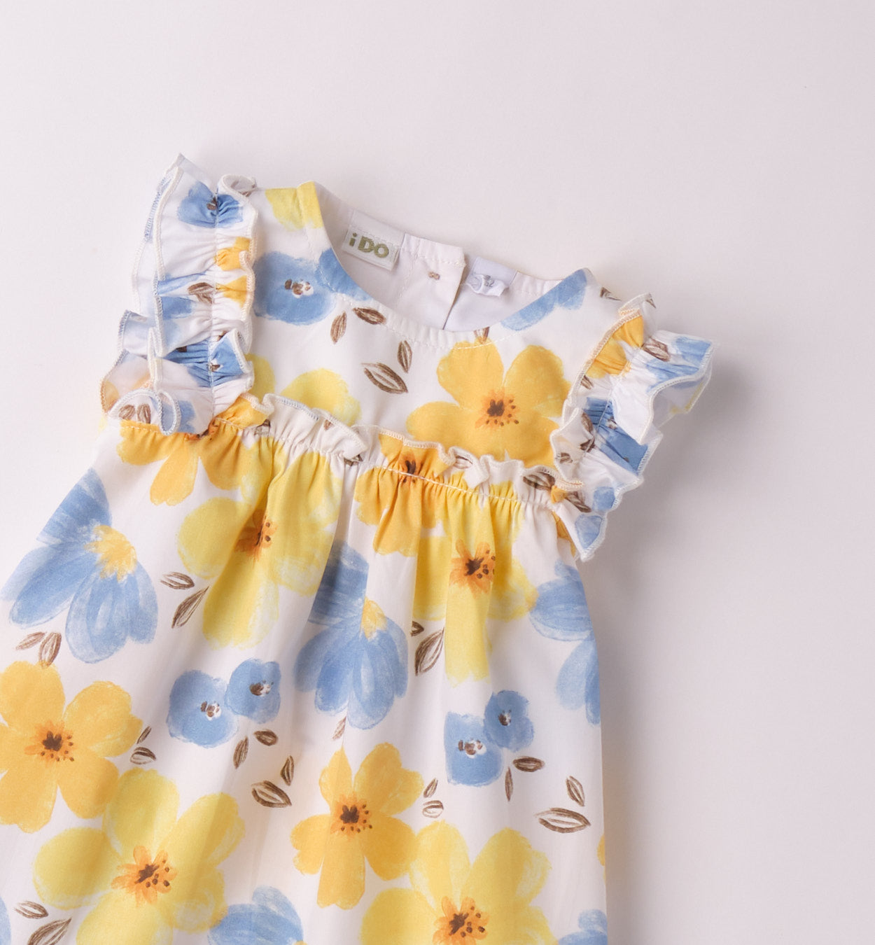 Dettaglio del vestito estivo per bambina con volant e stampa floreale vivace.
